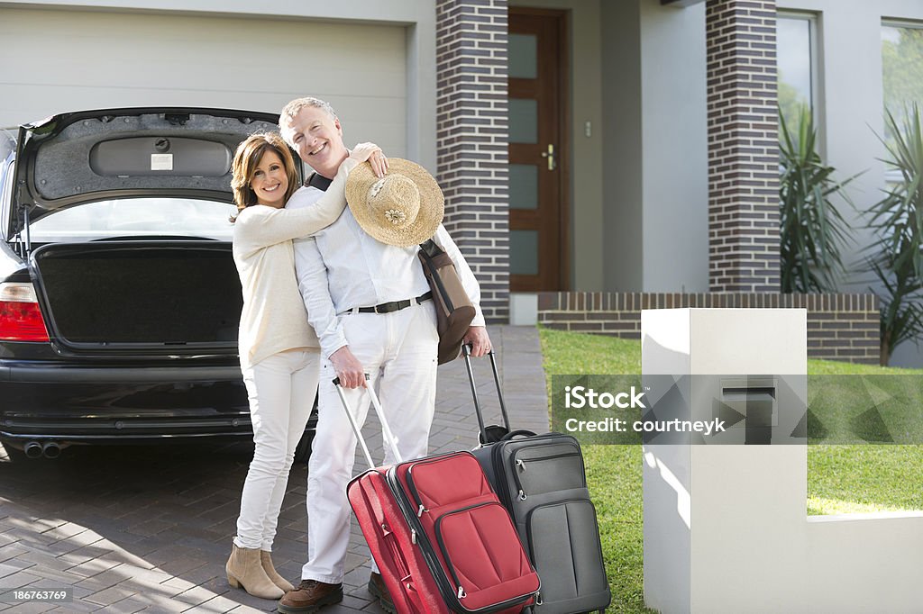 couple d'âge mûr avec les valises et voiture - Photo de Partir libre de droits