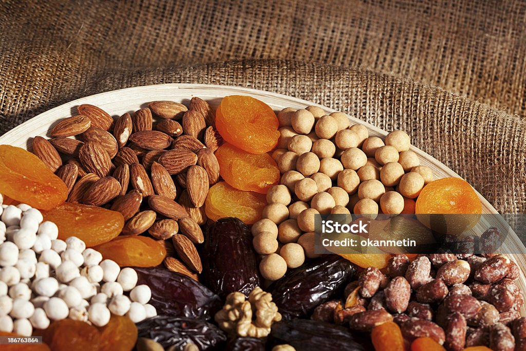 Dried fruits Date ,dried apricots, nuts, almonds, pistachios, pine nuts, chickpeas, peas, nuts, and Walnuts   in studio shot Almond Stock Photo
