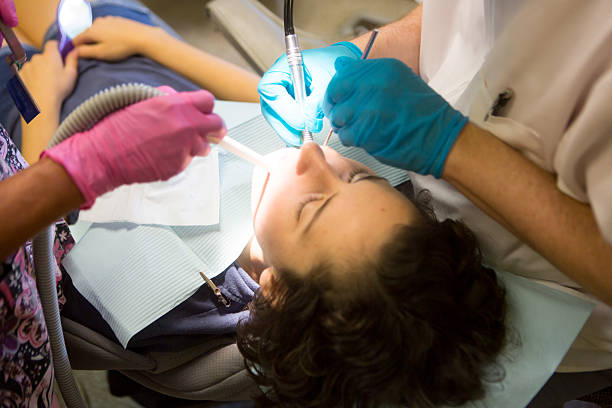 mujer joven obtener un llenado - mouth open dental drill holding doctor fotografías e imágenes de stock