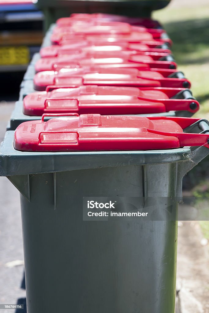 Detalhe fileira de plastick verde com tampas vermelhas as latas de lixo - Foto de stock de Coleção royalty-free