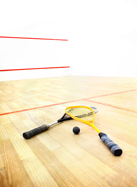 Squash rackets and  ball on a court.