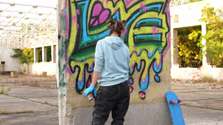 Young woman doing graffiti on the wall