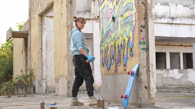 Young woman doing graffiti on the wall