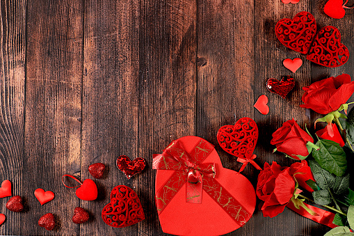 Concept for Valentine's Day or Women's Day, Mother's Day, banner. Greeting card, roses, hearts and gift boxes on a wooden background, happy holiday, birthday greetings, selective focus