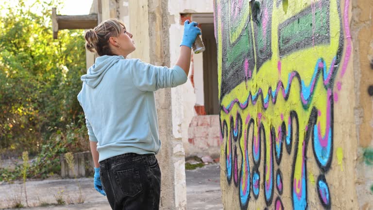 Young woman doing graffiti on the wall