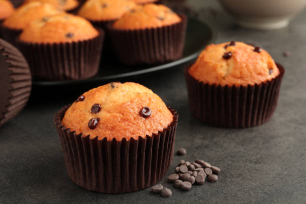 istock Delicious freshly baked muffins with chocolate chips on gray table, closeup 1867666606