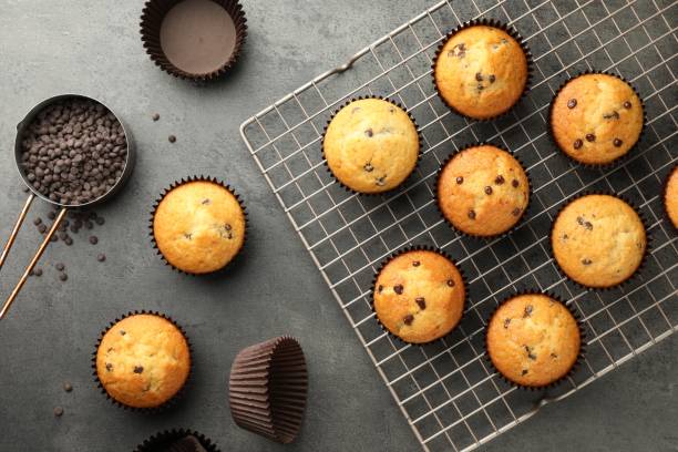 istock Delicious freshly baked muffins with chocolate chips on gray table, flat lay 1867667120