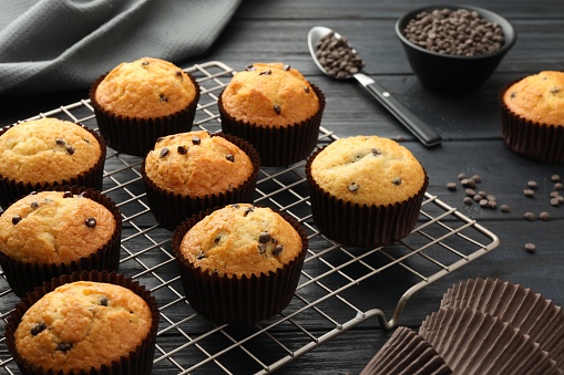Delicious freshly baked muffins with chocolate chips on dark gray table