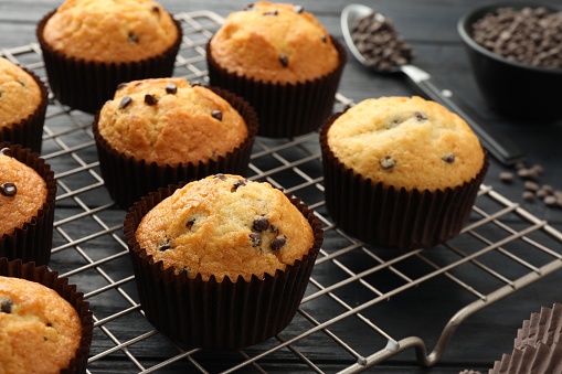 Delicious freshly baked muffins with chocolate chips on gray table, closeup