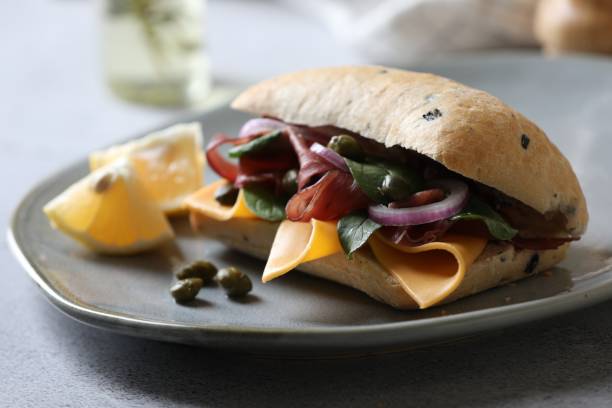 delizioso panino con bresaola, formaggio e cipolla su tavolo grigio chiaro, primo piano - bresaola foto e immagini stock