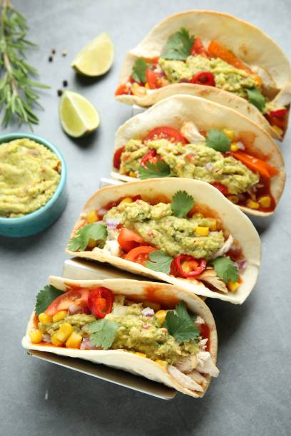 istock Delicious tacos with guacamole, meat and vegetables served on grey table 1867668784