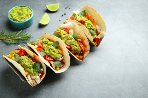 istock Delicious tacos with guacamole, meat and vegetables on grey table. Space for text 1867669295