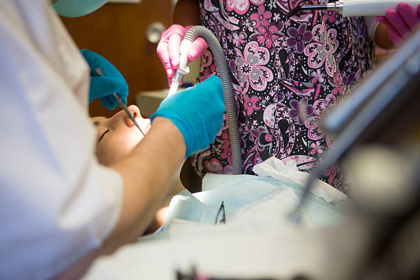 mujer joven obtener un llenado - mouth open dental drill holding doctor fotografías e imágenes de stock