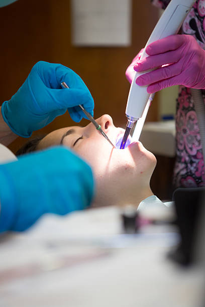 jovem mulher ficando um preenchimento - mouth open dental drill holding doctor - fotografias e filmes do acervo