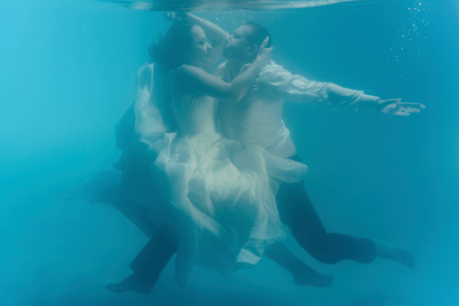 young couple underwater kissing .