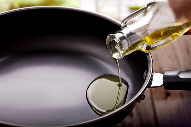 verser de l'huile sur frying pan manger - lubrication photos et images de collection