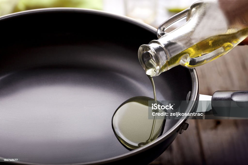 Pouring eating oil in frying pan pouring eating oil in frying pan Cooking Oil Stock Photo