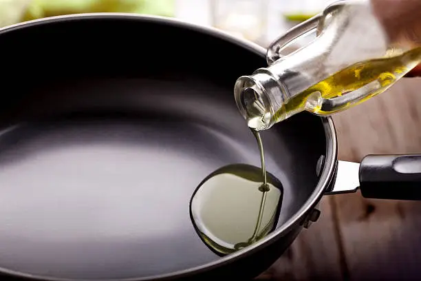 pouring eating oil in frying pan