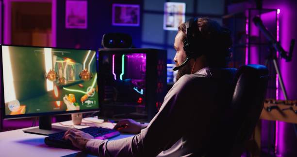 istock Man playing FPS videogame with friends, communicating through headphones mic 1867690997