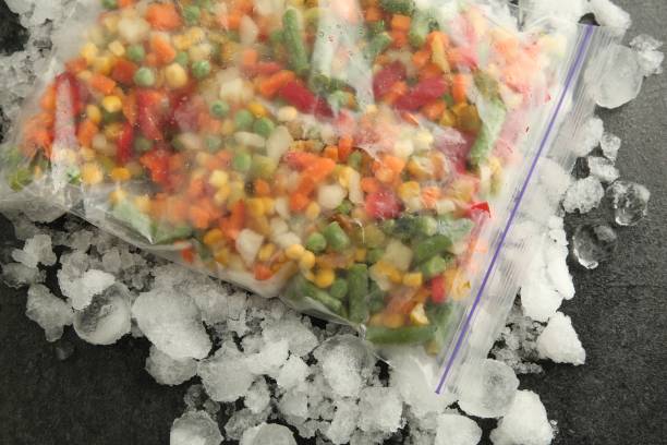 istock Zip bag with different frozen vegetables and ice on grey table, top view 1867696318