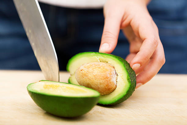 istock Young woman peeling avocado 186769805