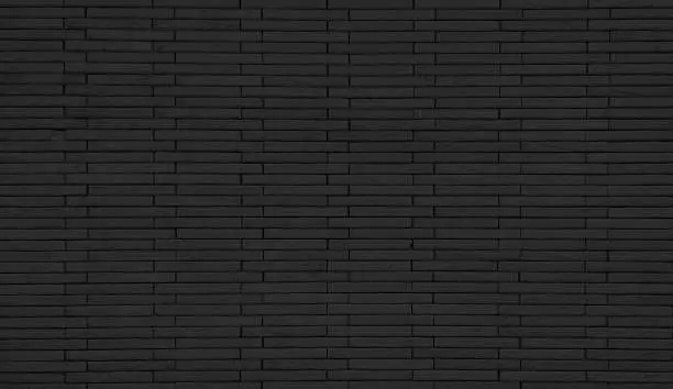 Photo of empty background of wide dark black brick wall texture. grunge brick wall stone textured, wallpaper of limestone. grid pattern of uneven interior rock stones. architectural wall design backdrop.