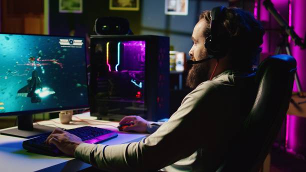 istock Man playing entertaining videogame with online friends, flying spaceship through galaxy together 1867711412