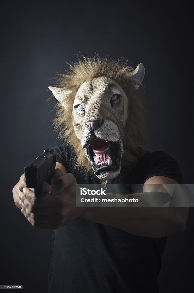 Robber in Lion mask Robber in lion mask holding a gun Adult Stock Photo
