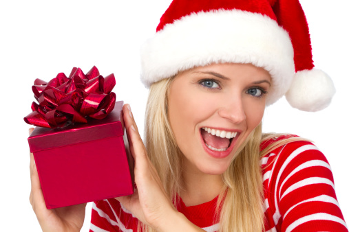 beautiful young blonde woman wearing santa hat and holding a red christmas gift box