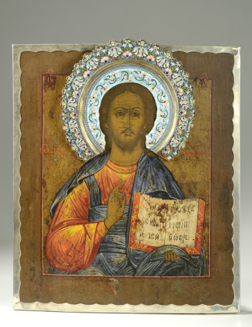 19th century Russian icon depicting Jesus Christ holding scripture.  It is an oil on board has an emaneled riza/halo and silver border, set on a gradient background.