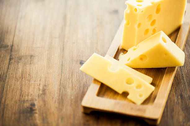 Emmental cheese placed on wooden board plate