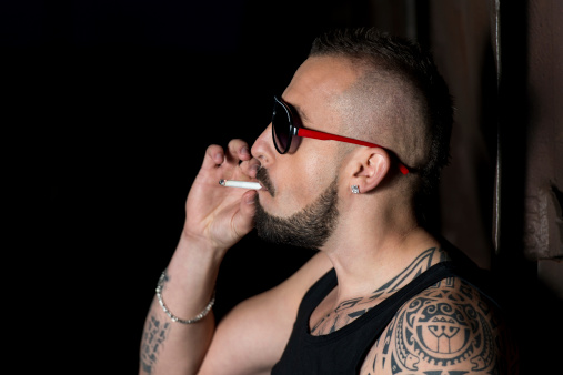 Man Smoking A Cigar  He Also Has A Healthy Growth Of Facial Stubble