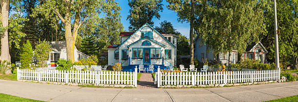 istock Idyllic summer cottage white picket fence lawn chairs panorama 186775675