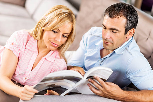 istock Couple reading a magazine at home. 186775859