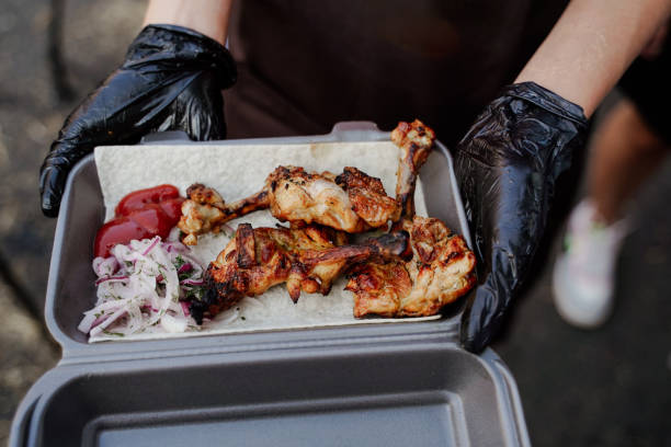 istock Chef serves lavash, grilled chicken, and marinated onions. Culinary artistry in a container, a delectable ensemble of gourmet flavors and presentation. 1867760256