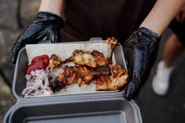 istock Chef serves lavash, grilled chicken, and marinated onions. Culinary artistry in a container, a delectable ensemble of gourmet flavors and presentation. 1867761299