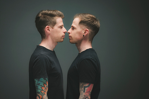 face to face twin brothers portrait studio shot.