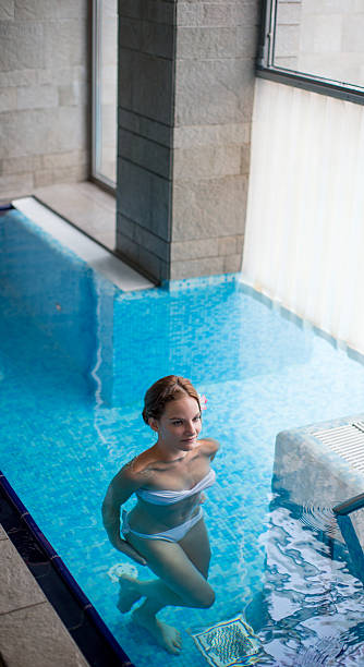 istock Beautiful young woman in a spa pool 186777020