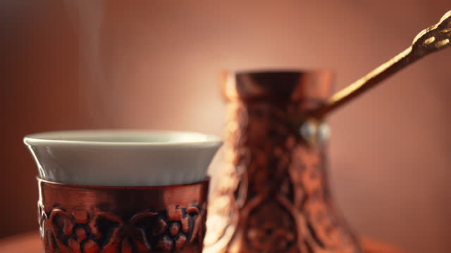 Steamy Turkish Coffee pot known as Cezve or Jezve and coffee cup