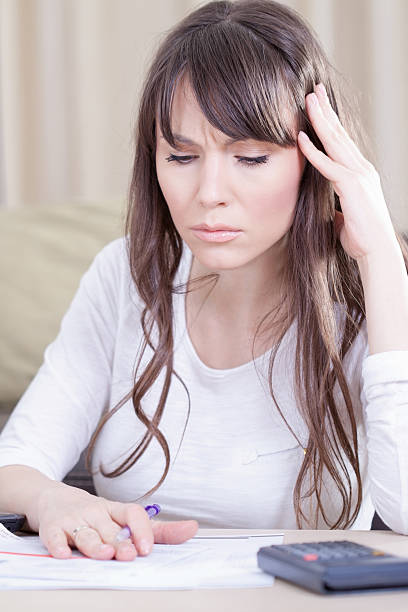 istock Concerned young woman looking at bills. 186778503