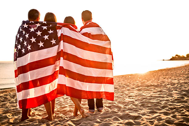 istock Americans wrapped in United States flag on beach 186779497