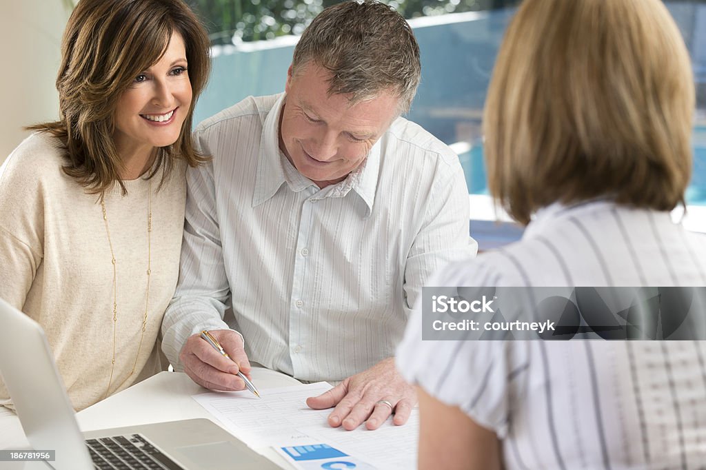 Casal Assinando Contrato em reunião com o conselheiro - Royalty-free Casal de Meia Idade Foto de stock