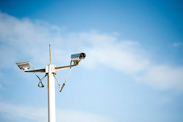 Surveillance Camera Security camera on the pole against blue sky. fz009 stock pictures, royalty-free photos & images