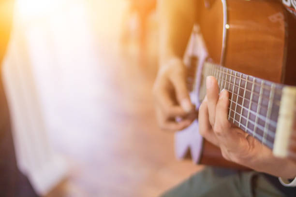 istock A young man is practicing playing guitar in a music practice room before performing in order to reduce the mistake of playing guitar on stage. Close Up Young man is holding guitar chords for practice. 1867882259