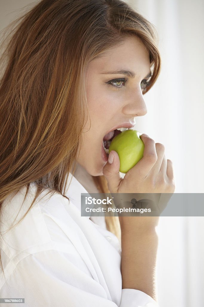 Mordere una mela verde brillante - Foto stock royalty-free di 20-24 anni