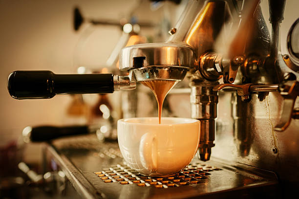 Pouring espresso Cup of espresso being poured from a domestic espresso machine. Shallow depth of field. espresso maker stock pictures, royalty-free photos & images