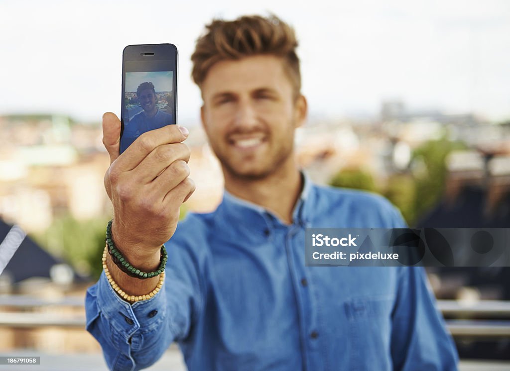Updating his profile picture A handsome young man taking a selfie with his holiday destination in the background 20-24 Years Stock Photo