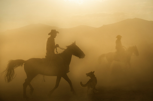 Kayseri,Turkey, 07/28/2018, The silhouette of  cowboys on horseback at sunset on a background