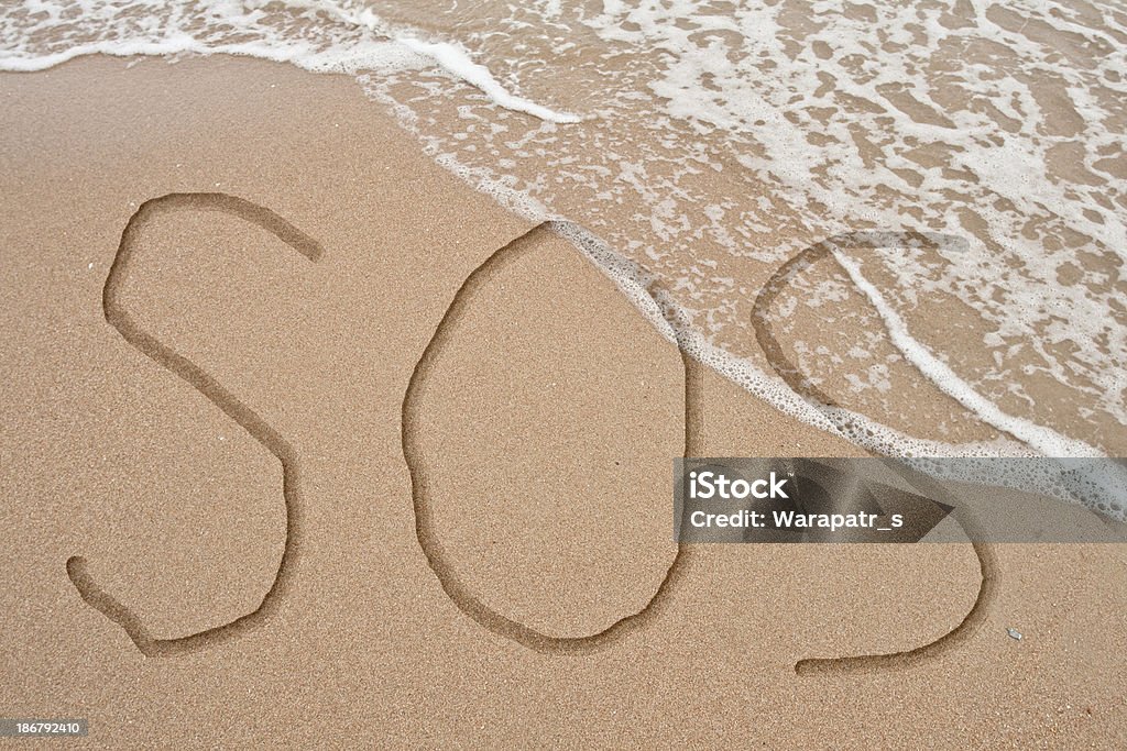 SOS texto sobre la arena y de la fase - Foto de stock de 2013 libre de derechos
