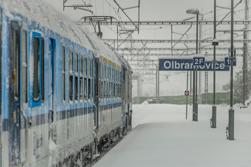 Electric trains near deep snowy platform and tunnel in Olbramovice CZ 12 02 2023